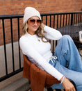 Load image into Gallery viewer, Woman sitting on a chair wearing a white long sleeved shirt, beige beanie, and blue jeans with a brick wall background. - Thread Vision Spotlight, Hill x Sarah, Sarah Hill