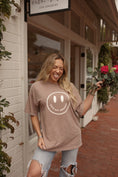 Load image into Gallery viewer, Smiling Morgan Willet holding roses wearing oversized washed smiley face graphic t-shirt by Thread Vision
