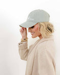 Load image into Gallery viewer, Woman wearing a light gray cap with 'Lime' text on a white background - Thread Vision Spotlight, Loverly Grey
