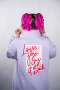 Load image into Gallery viewer, Person wearing a light purple hoodie with a text design on the back against a plain background - Thread Vision Client Spotlight, 10/10 Deanna Giulietti