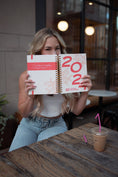 Load image into Gallery viewer, Woman holding a 2022 planner at a cafe - - Thread Vision Spotlight, Move Like Morgan