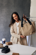 Load image into Gallery viewer, Woman holding a beige tote bag in an office setting - Thread Vision Client Spotlight, RESET by Serena Pitt