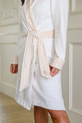Load image into Gallery viewer, White bathrobe with a belt with pink branding in a neutral setting - Thread Vision Spotlight, Remington Avenue
