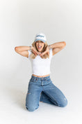 Load image into Gallery viewer, Woman wearing a white tank top, blue jeans, and a white cap with text on a white background - Thread Vision Spotlight, Move Like Morgan