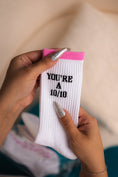 Load image into Gallery viewer, White sock with black text held by a hand against a neutral background - Thread Vision Client Spotlight, 10/10 Deanna Giulietti