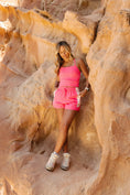 Load image into Gallery viewer, Woman in pink outfit standing in a rocky desert landscape - Thread Vision Spotlight, Day 1 Fitness, Kaylee Rogers