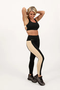 Load image into Gallery viewer, Woman wearing black and beige leggings with a white background - Thread Vision Spotlight, Day 1 Fitness, Kaylee Rogers