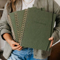 Load image into Gallery viewer, Person holding green spiral-bound notebooks with 'Nourish Naturally' text. - Thread Vision Spotlight, PCOS Planner