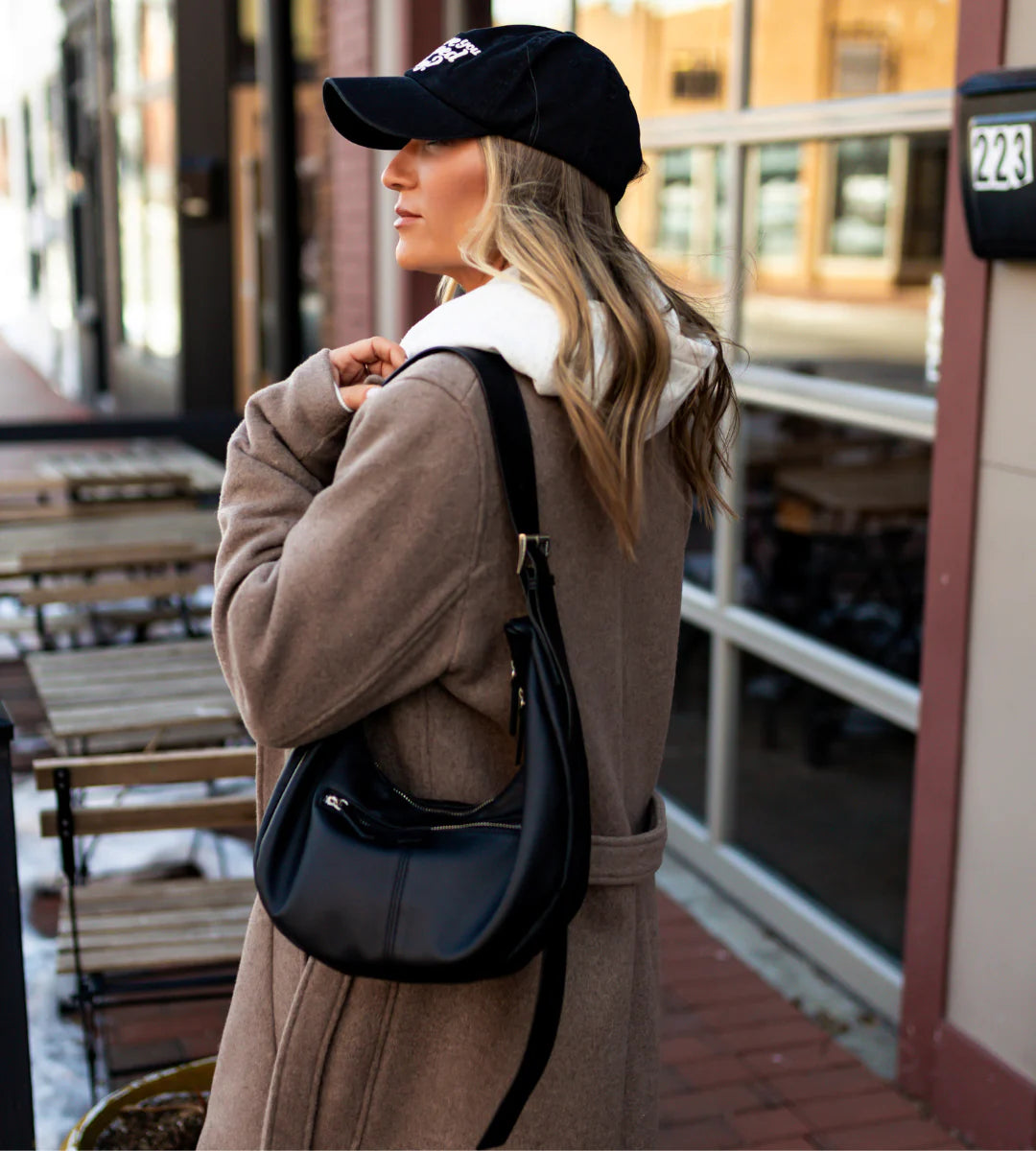 Woman in a brown coat and black cap with a black bag walking outdoors. - Thread Vision Spotlight, Hill x Sarah, Sarah Hill 
