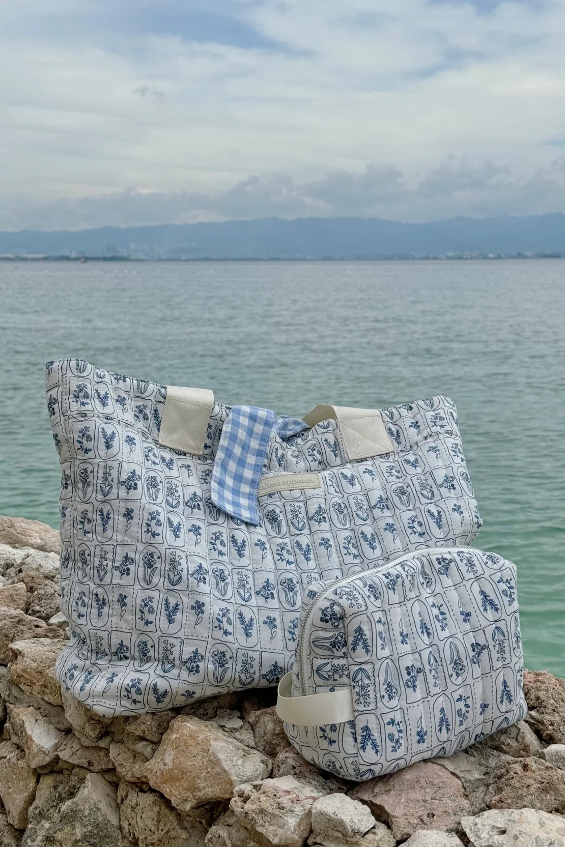 Two patterned bags on rocks with a body of water and sky in the background - Thread Vision Spotlight, Ignited Apparel