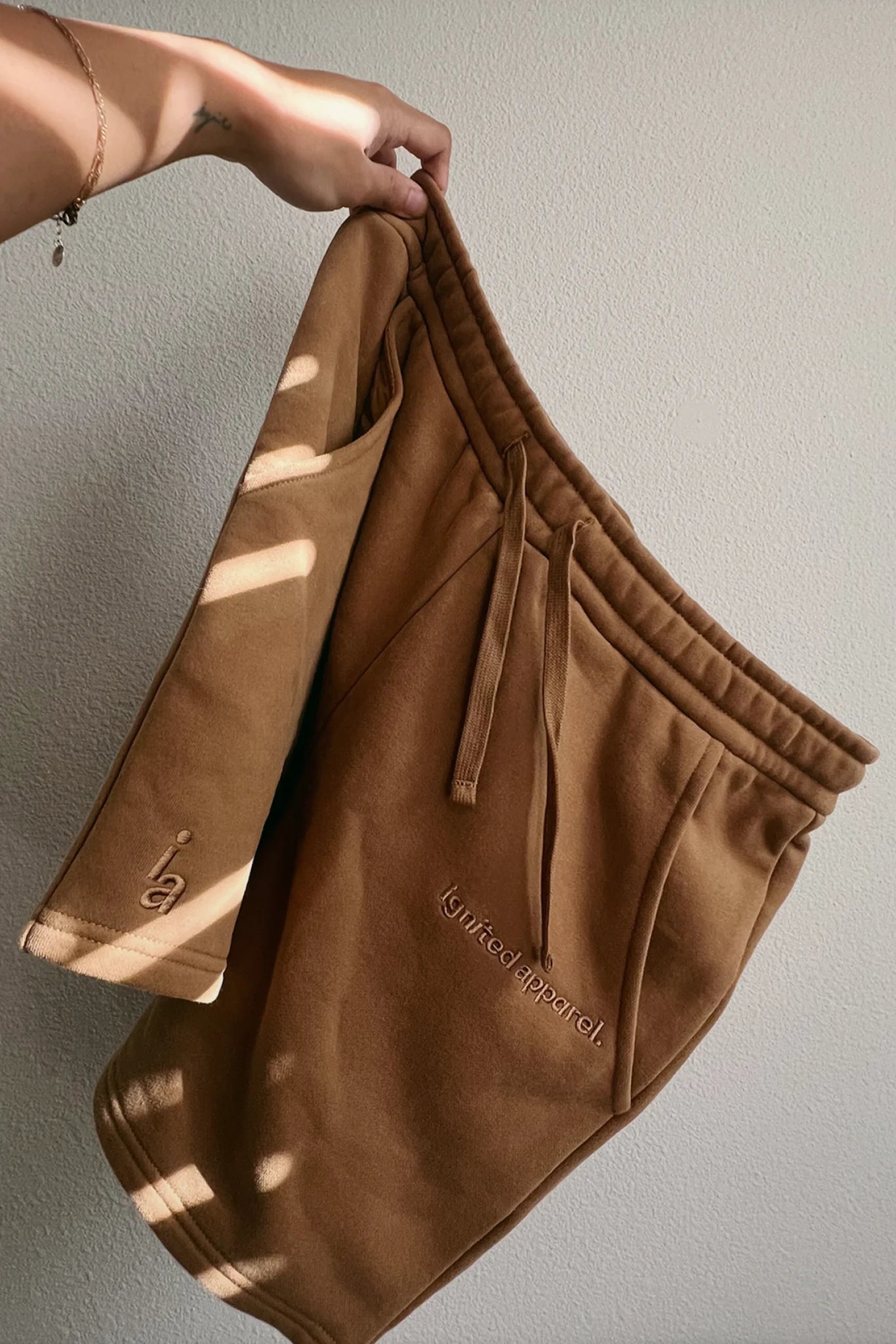 Brown shorts with a brand logo on a plain background - Thread Vision Spotlight, Ignited Apparel
