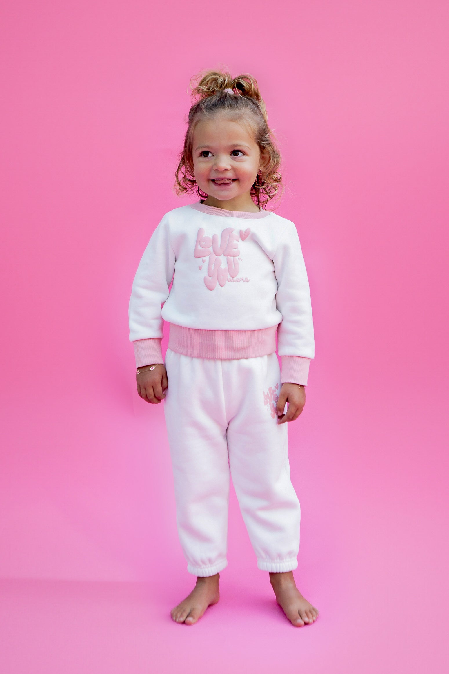 Child wearing a pink and white sweater and sweatpant outfit with text on a pink background - Thread Vision Spotlight, Rydel