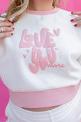 Load image into Gallery viewer, White sweatshirt with pink text 'LOVE YOU MORE' on a pink background - Thread Vision Spotlight, Rydel

