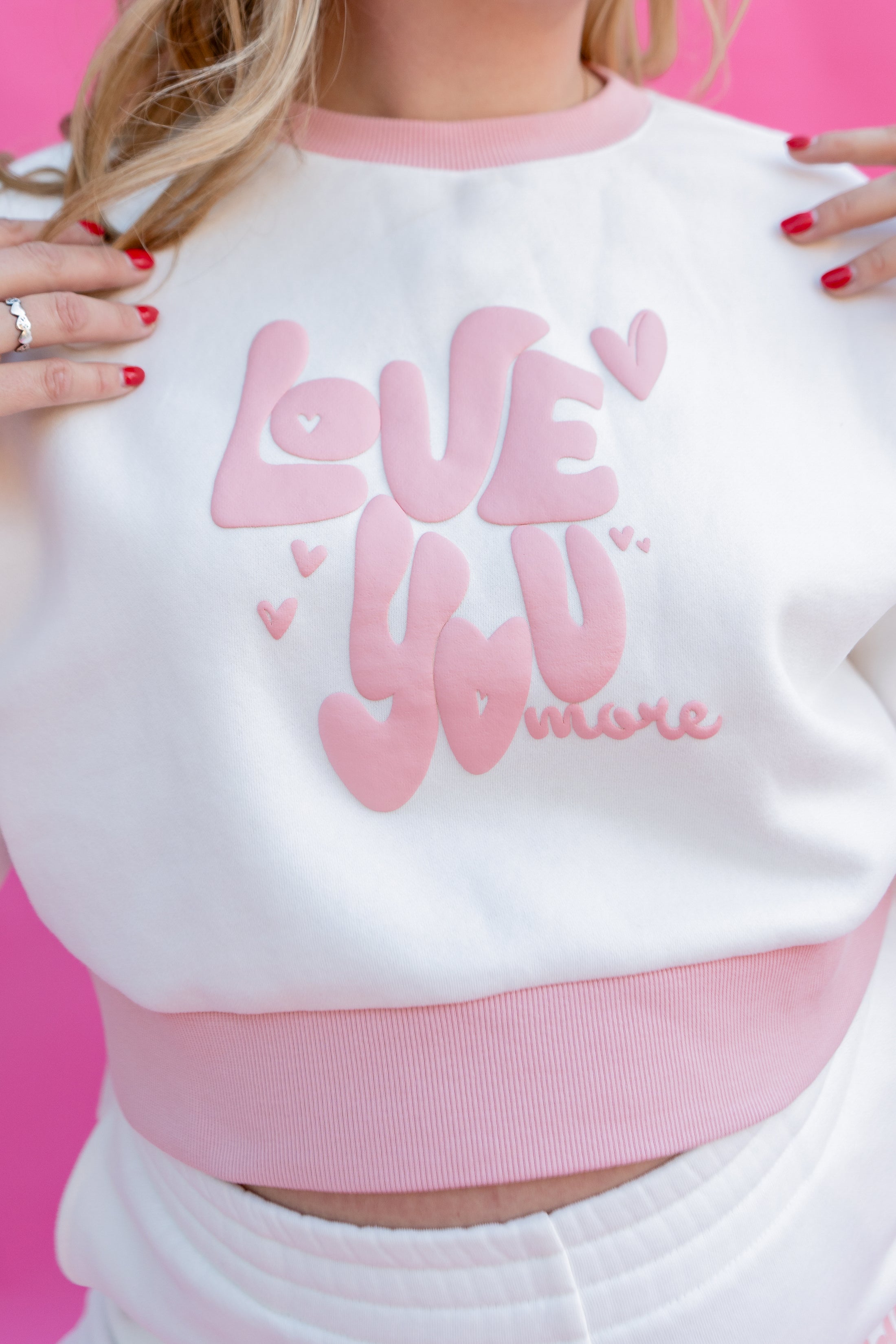 White sweatshirt with pink text 'LOVE YOU MORE' on a pink background - Thread Vision Spotlight, Rydel