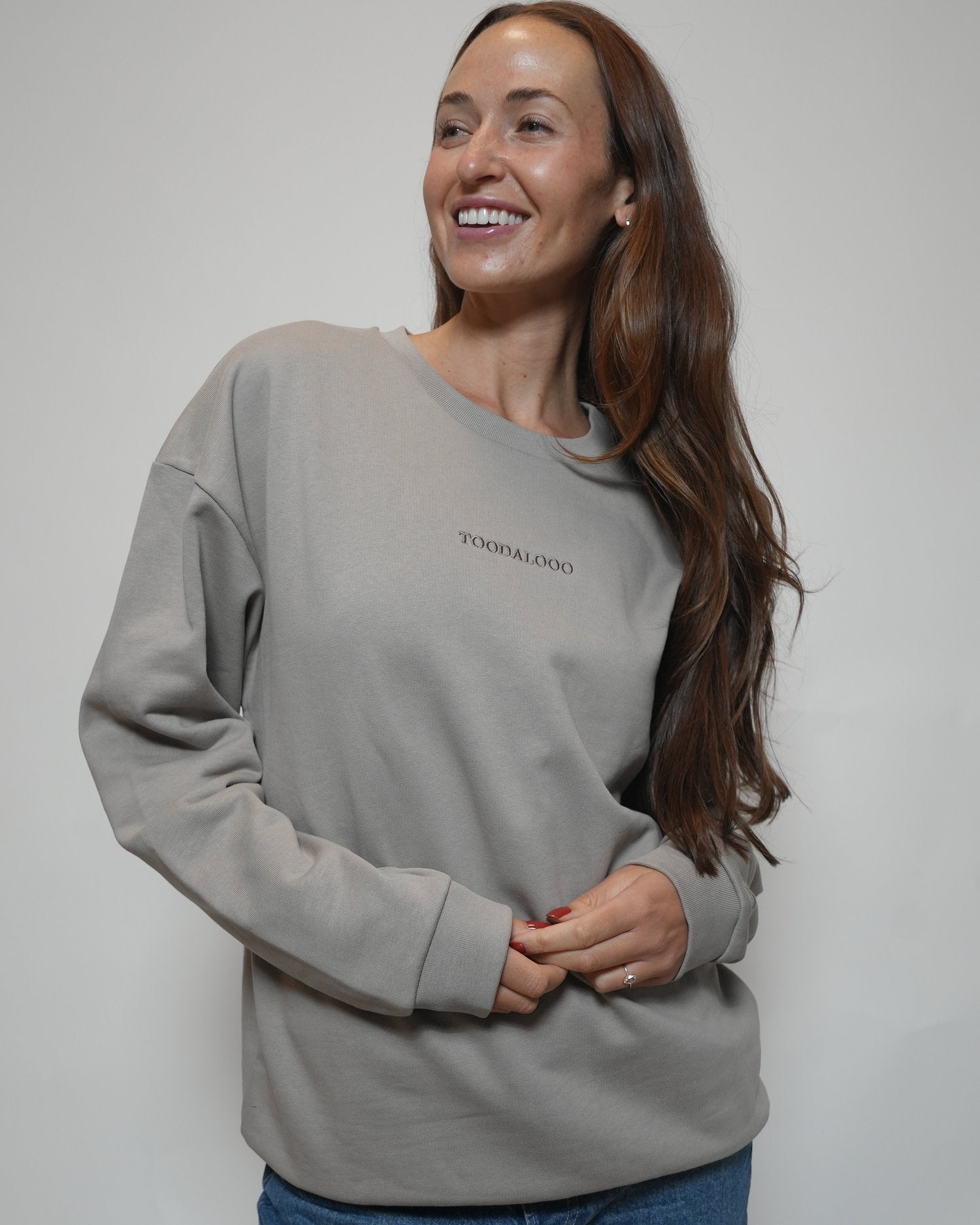 Woman wearing a gray sweatshirt with text on a plain background - Thread Vision Spotlight, Loe Hayley