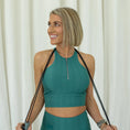 Load image into Gallery viewer, Woman in green athletic wear holding resistance bands against a white curtain background - Thread Vision Spotlight, Day 1 Fitness, Kaylee Rogers 

