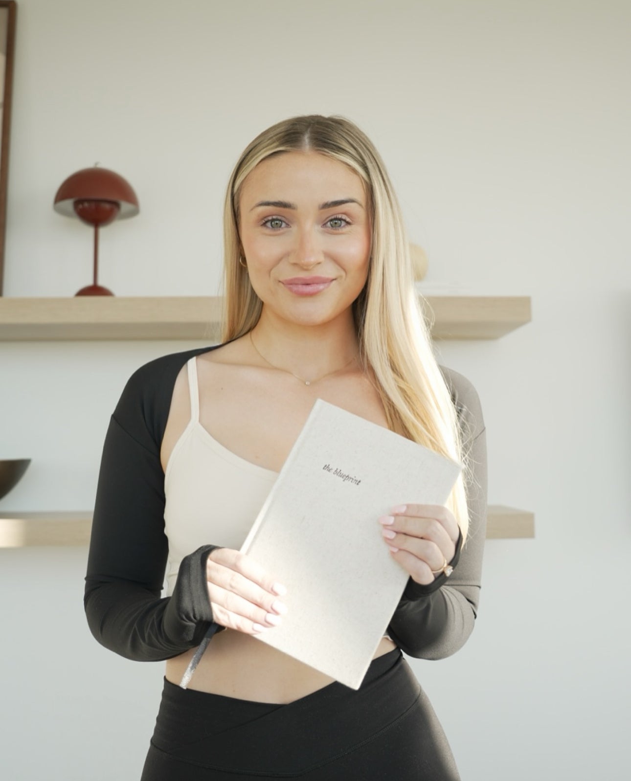 Woman holding a white folder with a brand logo indoors - Thread Vision Spotlight, HMBDY