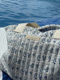 Load image into Gallery viewer, Patterned bag with a visible brand label against a blue water background - Thread Vision Spotlight, Ignited Apparel

