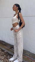 Load image into Gallery viewer, Woman in a white outfit standing against a white wall.  - Thread Vision Client Spotlight, Asha Bailey

