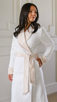 Load image into Gallery viewer, Woman wearing a white robe with a patterned trim against a neutral background - Thread Vision Spotlight, Remington Avenue

