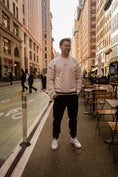 Load image into Gallery viewer, Man standing on a city street with buildings and tables in the background - Thread Vision Spotlight, Kinda Handsome
