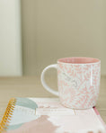 Load image into Gallery viewer, Pink mug with floral pattern on a notebook against a neutral background - Thread Vision Spotlight, Loverly Grey
