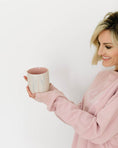 Load image into Gallery viewer, Woman in a pink sweatshirt holding a ceramic mug against a white background - Thread Vision Spotlight, Loverly Grey
