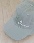 Load image into Gallery viewer, Light blue cap with 'shine on' text on a wooden surface - Thread Vision Spotlight, Loverly Grey
