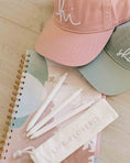 Load image into Gallery viewer, Pink and green hats on a notebook with 'Life is Lovely' products. - Thread Vision Spotlight, Loverly Grey
