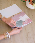 Load image into Gallery viewer, Person flipping through a planner with floral design on a wooden surface - Thread Vision Spotlight, Loverly Grey
