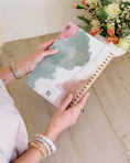 Load image into Gallery viewer, Person holding a spiral-bound notebook with floral design on a wooden surface - Thread Vision Spotlight, Loverly Grey

