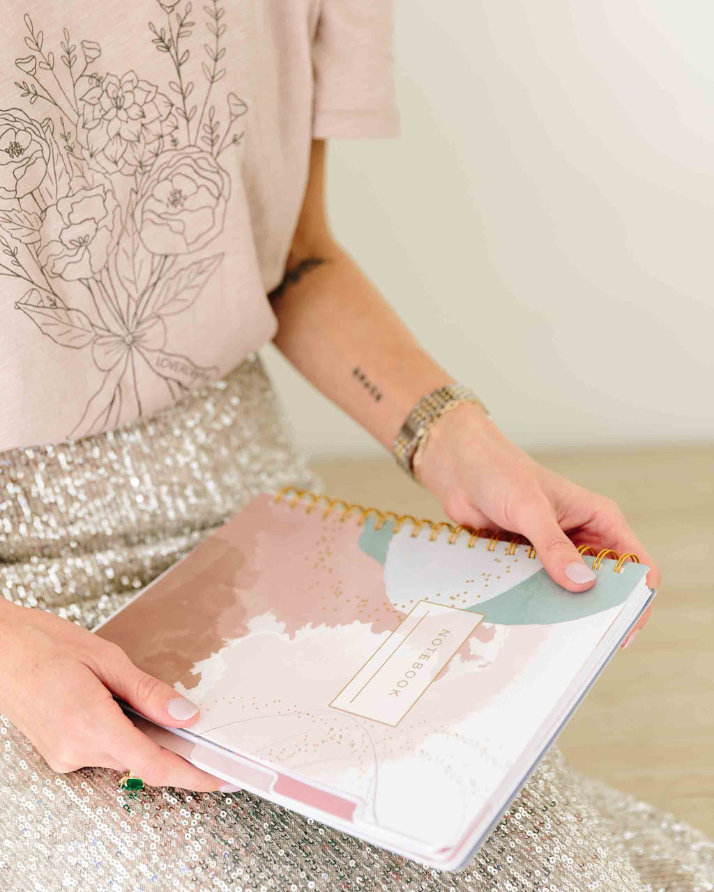Person holding a spiral-bound planner with floral design on cover - Thread Vision Spotlight, Loverly Grey