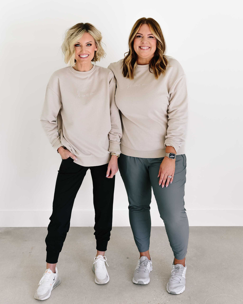 Two women wearing beige sweatshirts and pants standing against a white background - Thread Vision Spotlight, Loverly Grey