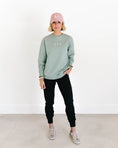 Load image into Gallery viewer, Person wearing a light green sweatshirt with 'FIV' logo, black pants, pink cap, and sneakers on a white background - Thread Vision Spotlight, Loverly Grey
