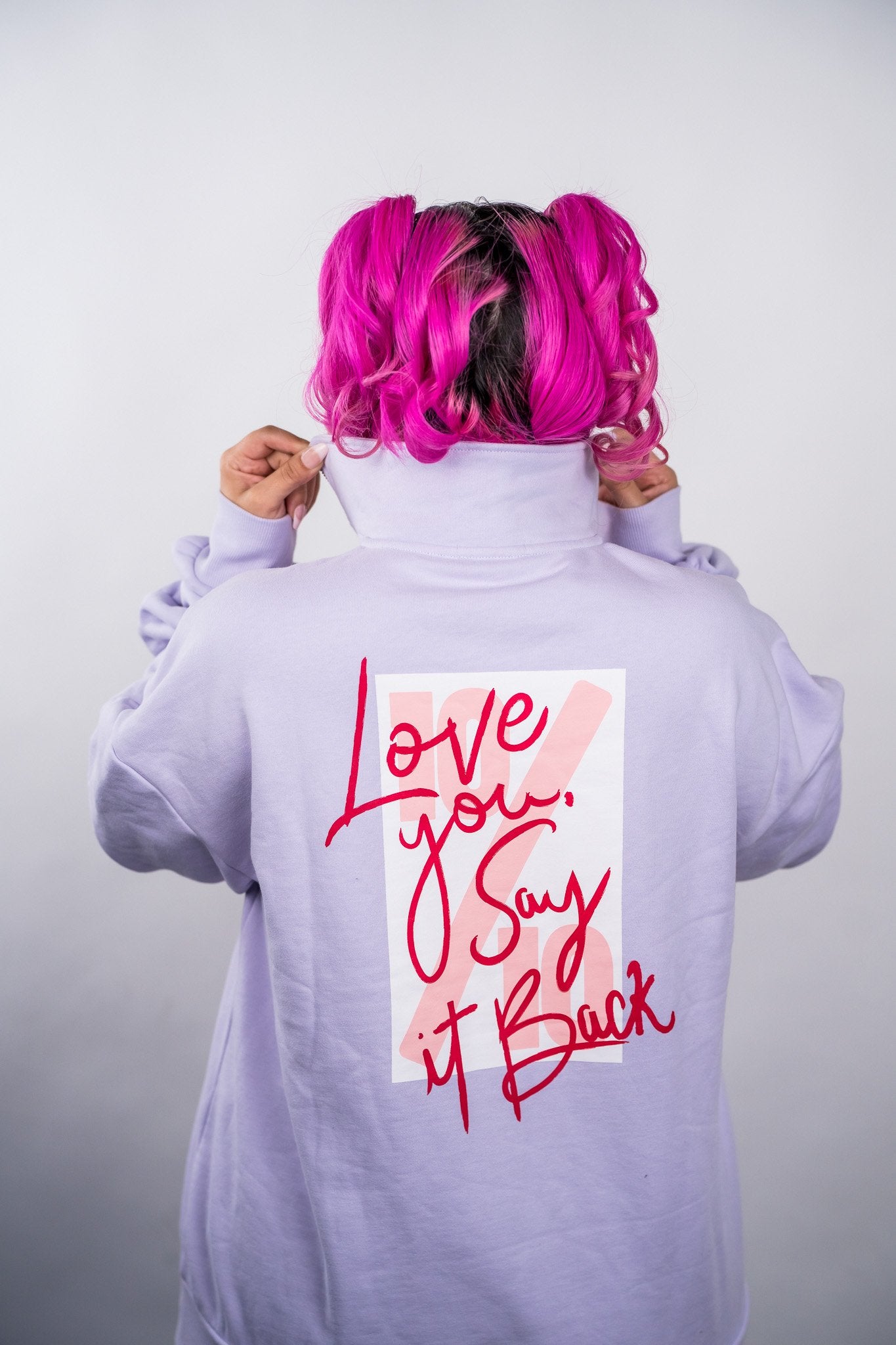 Person wearing a light purple hoodie with a text design on the back against a plain background - Thread Vision Client Spotlight, 10/10 Deanna Giulietti 