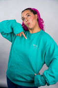 Load image into Gallery viewer, Person wearing a teal sweatshirt with text, posing against a plain background - Thread Vision Client Spotlight, 10/10 Deanna Giulietti 
