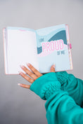 Load image into Gallery viewer, Hand holding an open notebook with 'I am proud of me' text on a gray background - Thread Vision Client Spotlight, 10/10 Deanna Giulietti 
