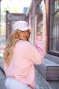 Load image into Gallery viewer, Woman wearing a pink sweatshirt and cap with a blurred background - Thread Vision Spotlight, Move Like Morgan
