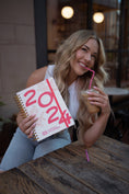 Load image into Gallery viewer, Woman holding a 2024 calendar and a drink with a straw outdoors. - Thread Vision Spotlight, Move Like Morgan
