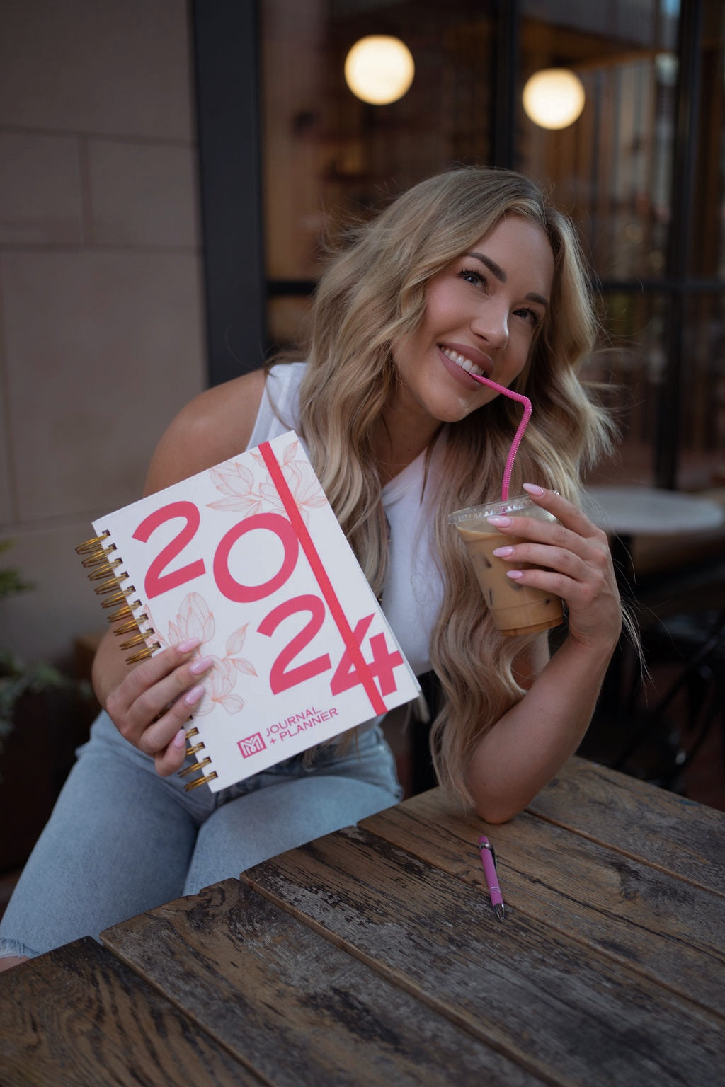 Woman holding a 2024 calendar and a drink with a straw outdoors. - Thread Vision Spotlight, Move Like Morgan