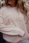 Load image into Gallery viewer, Beige sweatshirt with 'TRUST' text worn by a person with blonde hair. - Thread Vision Spotlight, Move Like Morgan
