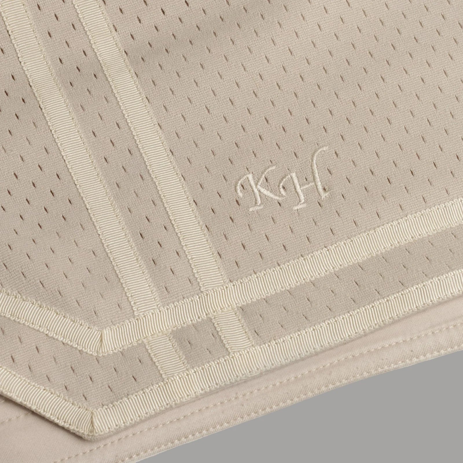 Beige textured fabric with embroidered initials on a gray background - Thread Vision Spotlight, Kinda Handsome