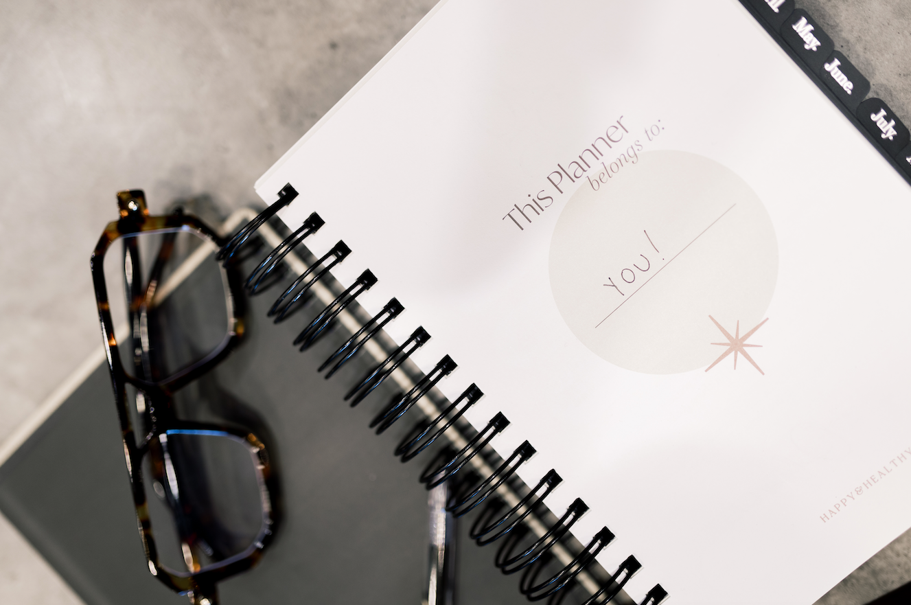 Spiral-bound planner with glasses on a textured surface - Thread Vision Client Spotlight, Skinny Hangover