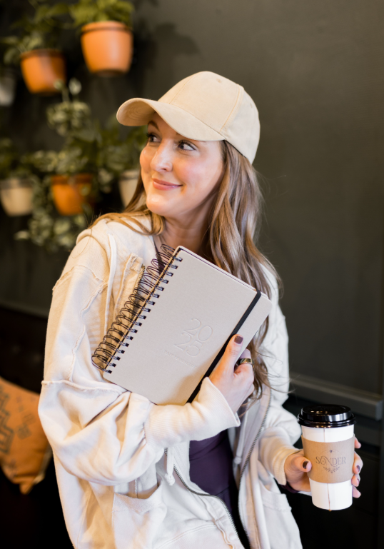 Woman holding a notebook and a coffee cup in a casual setting - Thread Vision, Client Skinny Hangover