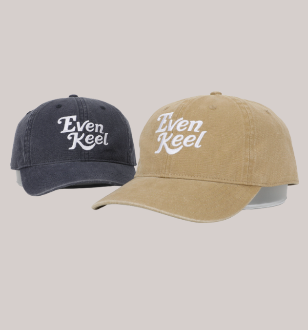Two baseball caps, one navy and one beige, with 'Even Keel' logo on a light gray background. - Thread Vision, Client Even Keel
