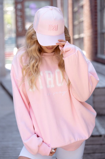 Person wearing a pink sweatshirt and cap outdoors -  - Thread Vision, Client Logo, Move Like Morgan