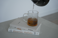 Load image into Gallery viewer, Tea being poured into a glass mug on top of a book titled 'Atomic Habits'.  Thread Vision Spotlight, HMBDY
