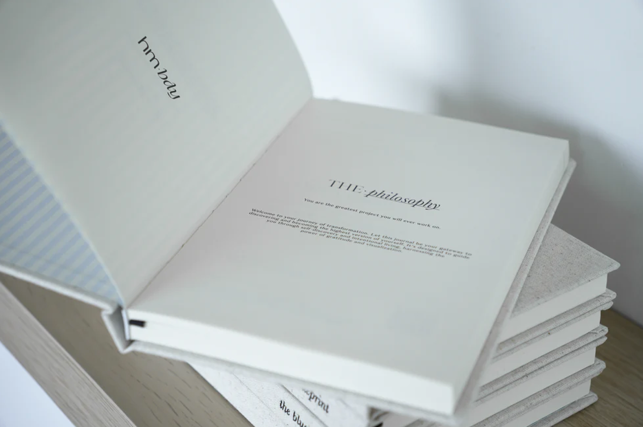 Stack of white books with text on a light surface Thread Vision Spotlight, HMBDY