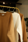 Load image into Gallery viewer, Two sweatshirts, one brown and one white, hanging on a gold rack. - Thread Vision Spotlight, Ignited Apparel
