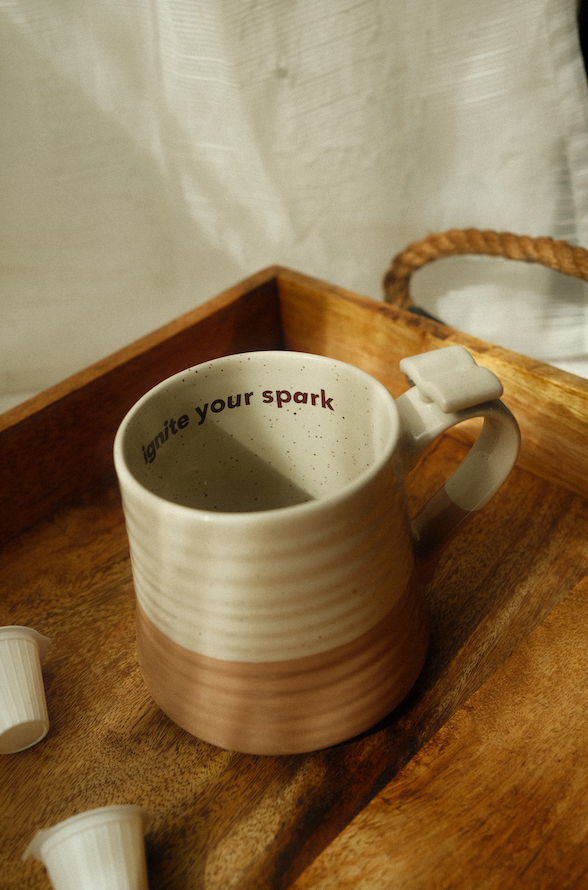 Ceramic mug with 'ignite your spark' text on a wooden tray - Thread Vision Spotlight, Ignited Apparel